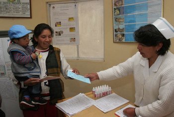 A mother receives medicines and oral rehydration salts for her child who is suffering from diarrhoea.