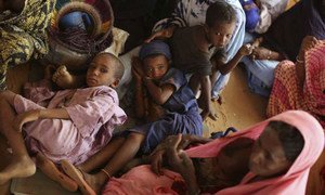 Malian children take shelter from a dust storm in Burkina Faso's Goudebou refugee camp. The needs for displaced Malians remain great.