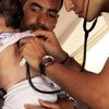 Un père syrien porte sa petite fille qui est examinée par un médecin en Turquie.