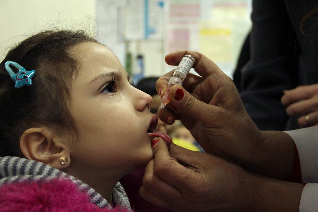 Mtoto akipatiwa chanjo ya polio kwa njia ya matone katika kituo cha afya mjini Damascus, Syria