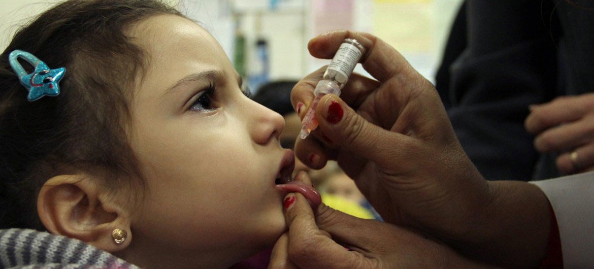 A girl receives a dose of oral polio vaccine at a health centre in Damascus, Syria.
