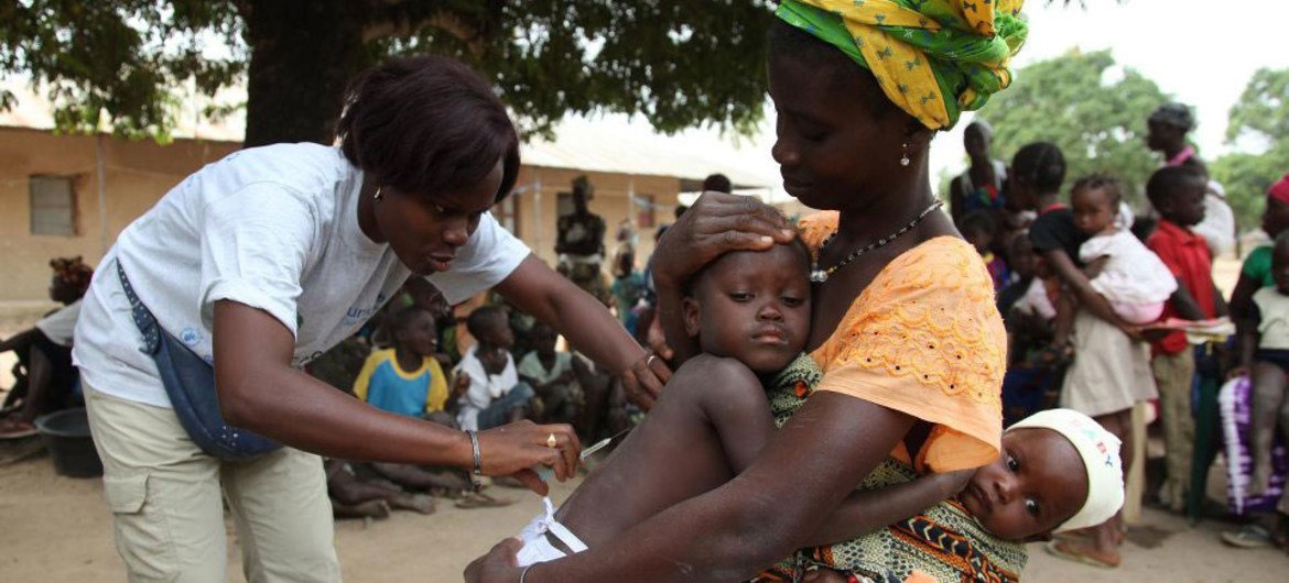 A nurse gives a measles vaccination to a child in Guinea-Bissau.