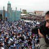 La photographe Farzana Wahidy, en train de couvrir une manifestation de femmes demandant davantage d'autonomisation, à Mazar-i-Sharif, dans le nord de l'Afghanistan.