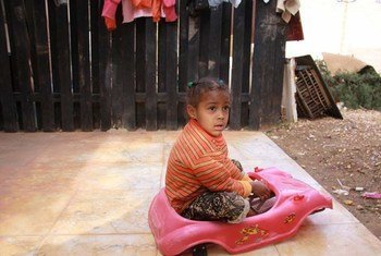 Une fillette déplacée joue à l'extérieur du logement où sa famille a été réinstallée à Benghazi.