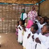 Des enfants accueillent en chantant la Secrétaire générale adjointe aux affaires humanitaires, Valérie Amos, dans le camp de Zamzam au Darfour
