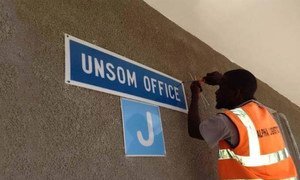 A worker putting up a sign for the new UN Assistance Mission in Somalia (UNSOM) Headquarters in Mogadishu.