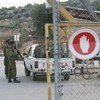 Soldados israelíes inspeccionan un vehículo que entra a Cisjordania. Foto: IRIN/Tom Spender
