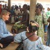 Humanitarian Coordinator for the Central African Republic, Kaarina Immonen (left), talks to people waiting to receive food assistance at the community hospital in Bangui.