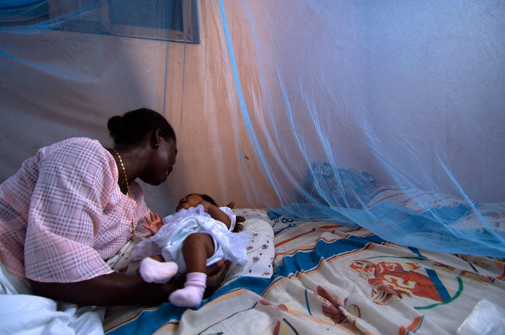 在加纳，这名婴儿安睡在浸药防疟疾蚊帐中。