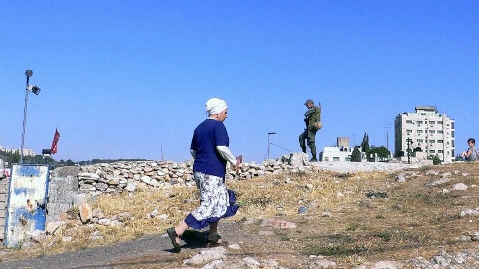 Une habitante d'une colonie de peuplement israélienne passe à proximité d'un soldat israélien à Jérusalem-Est (photo d'archive).