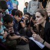 UNHCR Special Envoy Angelina Jolie (right) records the stories of refugees who have just escaped the war in Syria at the Jaber border crossing in Jordan on 18 June 2013.