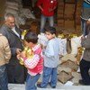 Families collect their food rations at a distribution point in Tartous, a port city in western Syria.