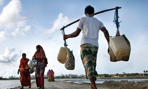 Above, people carry drinking water in Bangladesh.