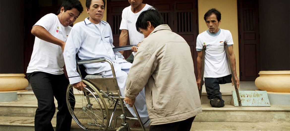 Un hombre con discapacidad recibe ayuda durante un simulacro de evacuación en Dong Phuoc, Vietnam.