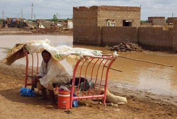 A man on a flooded street in Sharg al Nil Area, Khartoum, Sudan.
