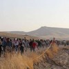 Syrians who fled across the Peshkhabour border into Kurdistan in northern Iraq walk towards a makeshift reception centre.