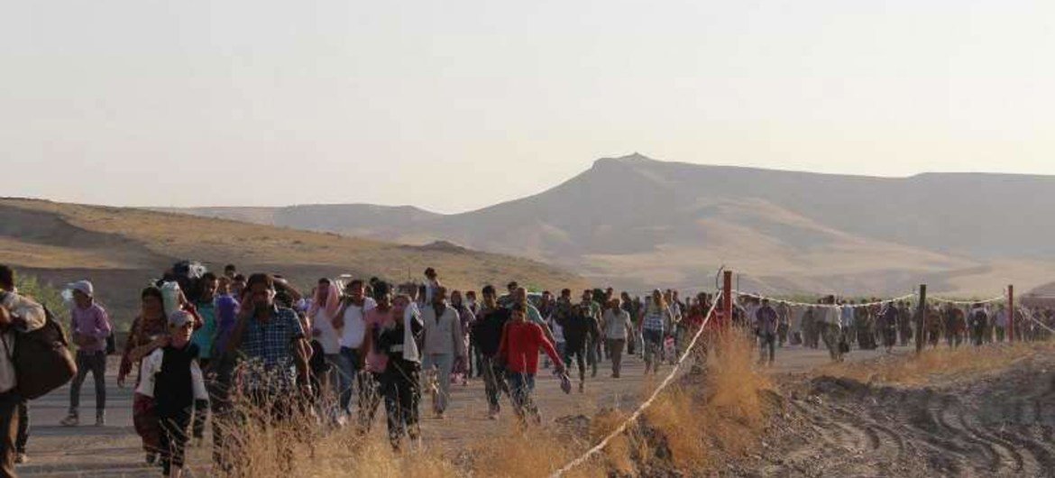 Syrians who fled across the Peshkhabour border into Kurdistan in northern Iraq walk towards a makeshift reception centre.