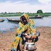 A villager takes extra precautions to keep her supply of water clean in Niger.