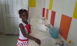 A little girl enjoys bathroom facilities donated by UN agencies at a school in Guapi, Colombia.