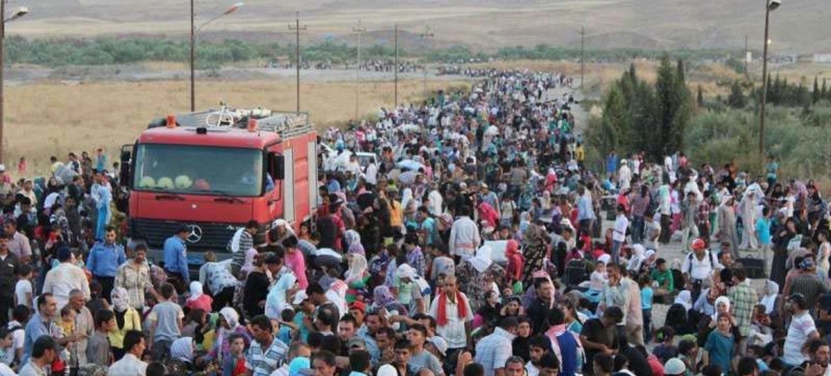 Thousands of Syrians stream across the border into Iraq in search of shelter.