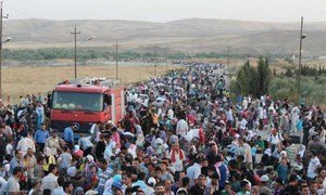 Thousands of Syrians stream across the border into Iraq in search of shelter.