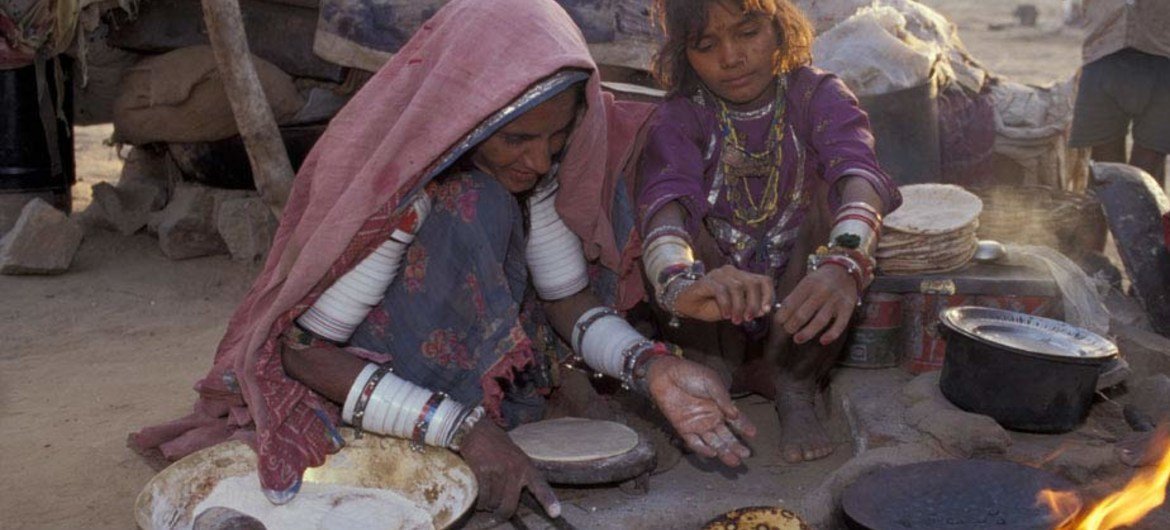 Migrant workers in India cook a meal. 