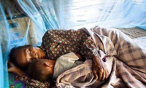 With support from a Global Fund grant, a woman and a child sleep under an insecticide-treated net in Atsapanethong District, Laos.