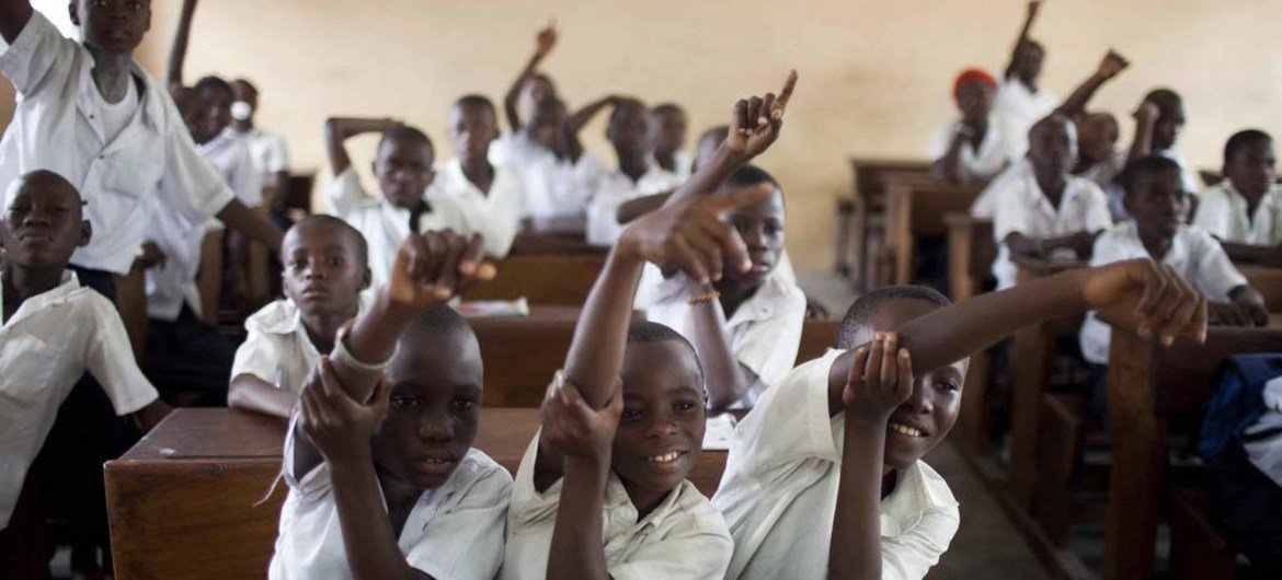 Students at a primary school in the Democratic Republic of the Congo (DRC) raise their hands to answer a class question.