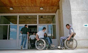 Men and women at the entrance of a school in Romania that teaches people with disabilities.