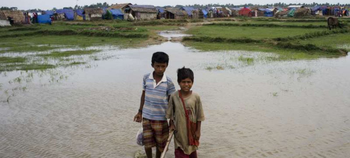 Two displaced boys in Rakhine state, Myanmar, play in a river. Daily life is still a struggle for communities like theirs and some people risk their lives at sea in their search for safety and stability.