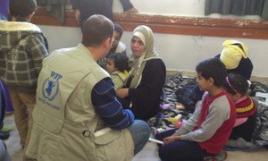 WFP staff distributing ready to eat food to families who fled from Yarmouk, Syria.