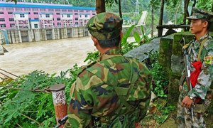 Two Kachin soldiers stand guard opposite a Chinese dam in northern Kachin state, where more than 85,000 people have been displaced by conflict.