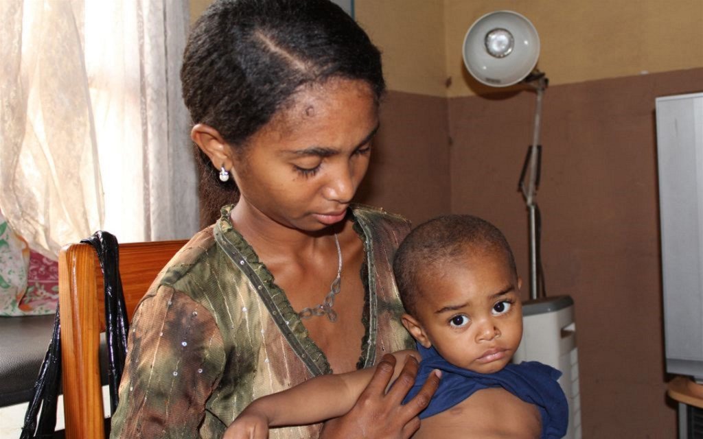 Une femme et son enfant dans une clinique de Madagascar, pour une visite de routine de contrôle de la pneumonie.