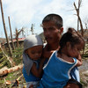 A man carrying his children in Tacloban, Leyte, Philippines, after Super Typhoon Haiyan (local name Yolanda) hit the province.