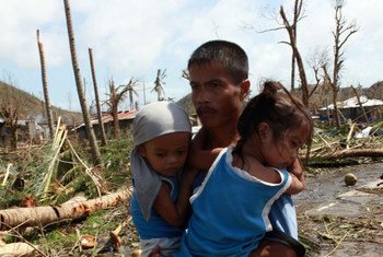 A man carrying his children in Tacloban, Leyte, Philippines, after Super Typhoon Haiyan (local name Yolanda) hit the province.