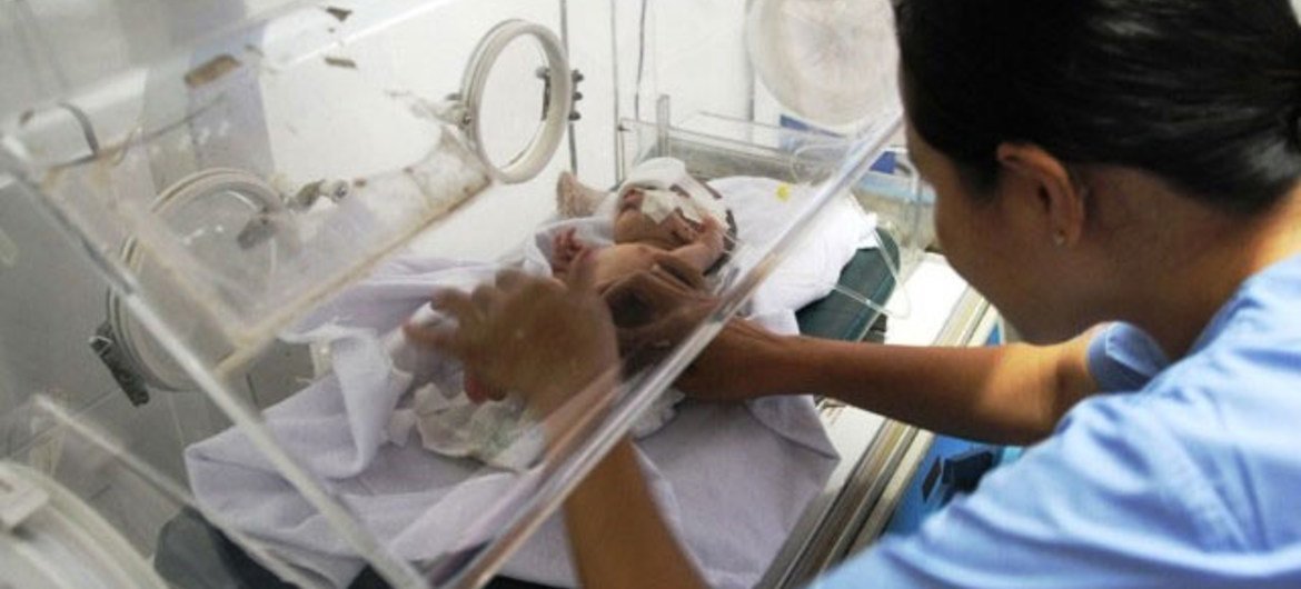 A health worker places a preterm newborn into an incubator to improve the chances of survival.