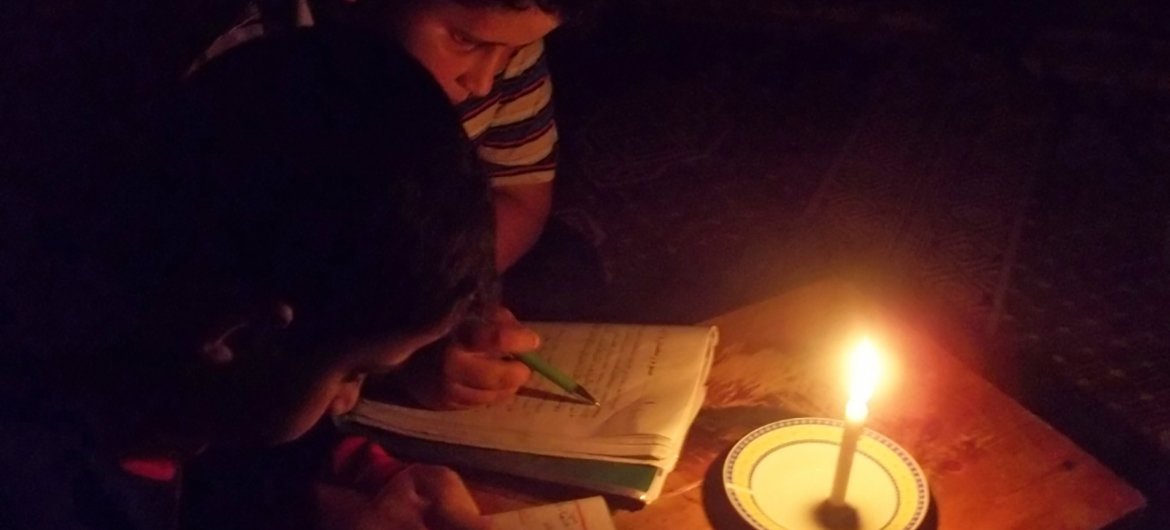 Children read by candle light due to limited hours of electricity in the Gaza Strip. 