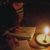 Two children read by candle light in Gaza.