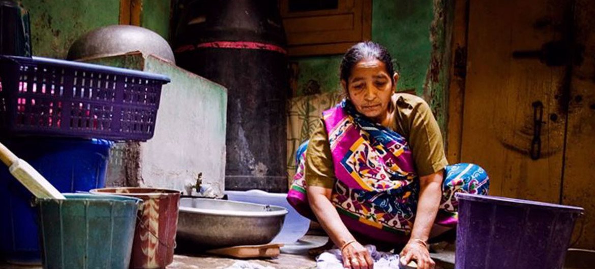 印度新德里，一名家政工人正在手洗衣物。