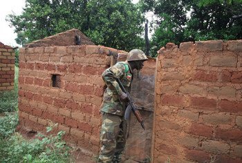 A regional peacekeeper checks an abandoned home in one of many deserted villages lining the road south of Bossangoa, Central African Republic.
