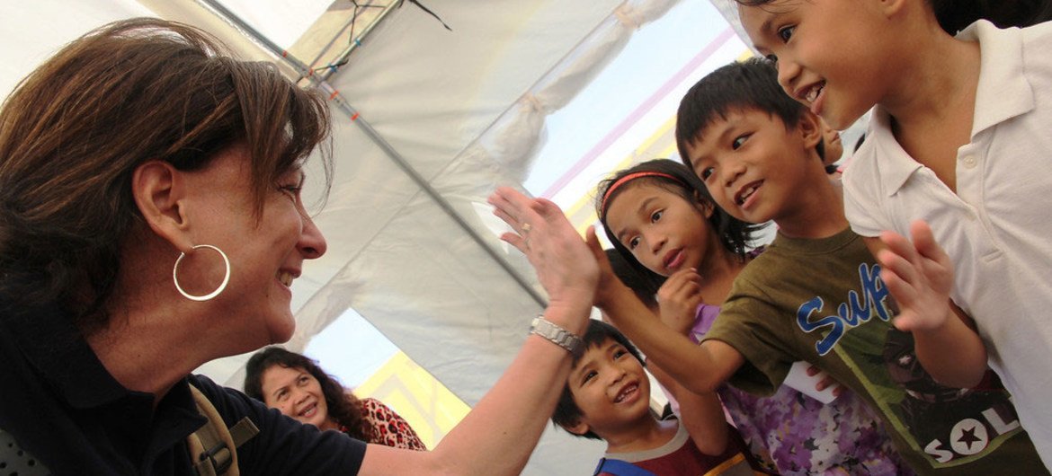 Resident and Humanitarian Coordinator Luiza Carvalho cheering children at temporary learning centre in Palo central school, the Philippines, during a donors mission to the region devastated by Typhoon Haiyan.