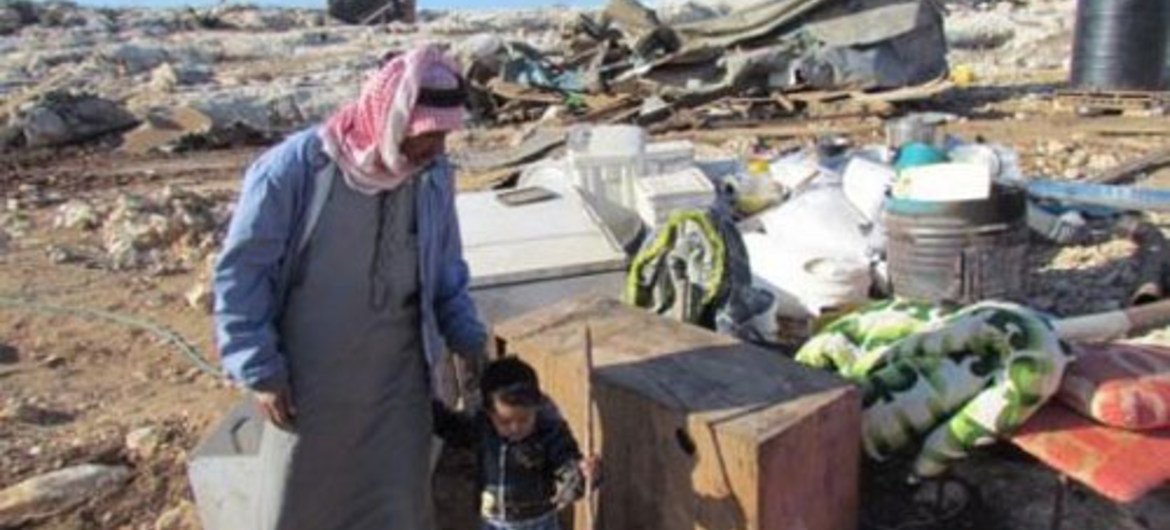 Father and son standing with their belongings following the latest demolitions in the West Bank, which displaced 68 people.