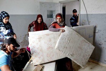 A group of Syrian refugee women move into their new home, a former chicken farm, near Qoubaiyat, Lebanon.