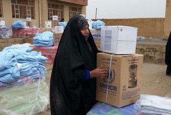 An internally displaced woman in Anbar province collects aid.