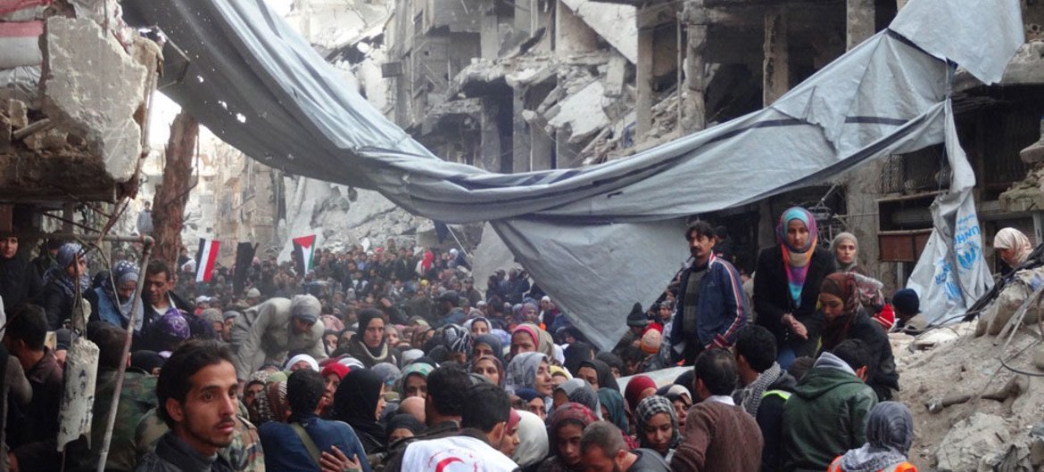 Desperate crowd awaits relief aid at Yarmouk Palestinian refugee camp in Damascus.
