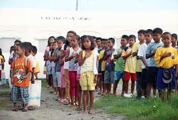 Children sing the Philippine national anthem, during a flag-raising activity before classes begin at a school which was affected by Typhoon Haiyan.