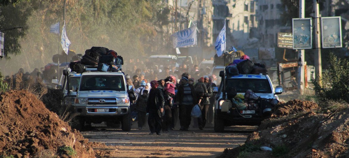 UN vehicles lead the evacuation from the Old City of Homs, Syria, during a three-day "humanitarian pause" in early February 2014.