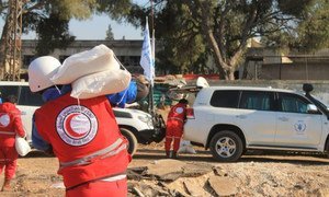Syrian Arab Red Crescent (SARC) staffers carrying WFP aid for people stranded in besieged Old Homs City during a humanitarian pause in the fighting.