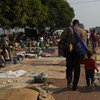 جمهورية أفريقيا الوسطى، رجل وإبنه يمشيان في موقع مزدحم للنازحين في العاصمة بانغي. صورة مفوضية شؤون اللاجئين / س. فيلبس