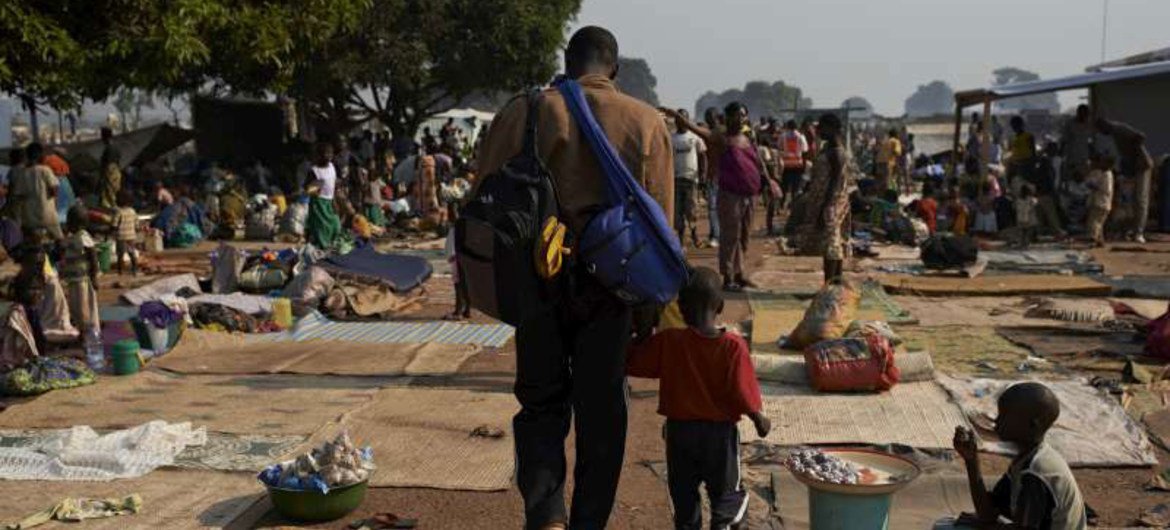 A man and his child walk through a crowded site for internally displaced people in the Central African Republic capital, Bangui, where many people remain at risk.